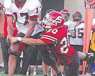 Mike Kunzer (20) strips the ball from Landon Smith as Eric Ahmer (5) tries to get in on the play Friday night in Struthers.