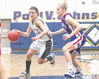 Taylor Hvisdak (12) tries to drive to the hoop as Hannah Mowery plays defense Thursday night in Lowellville.