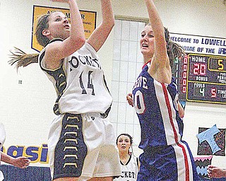 Emily Carlson (14) pulls up for two as Hannah Shrader (20) plays defense Thursday night in Lowellville.