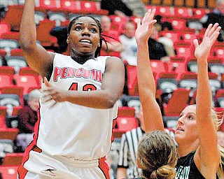 YSU Penguin Brandi Brown finds a hole between her defenders Adrian Ritchie (13) and Kayla Tetschlag of Green Bay and shoots.