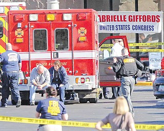 Emergency personnel work at the scene where Rep. Gabrielle Giffords, D-Ariz., and others were shot outside a Safeway grocery store in Tucson, Ariz. on Saturday, Jan. 8, 2011.