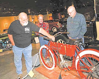 Bruce Williams of Cortland, left, talks about the 1908 Crouch motorcycle with Randy Kretz of Newbury, Ohio, center, and John Snodgrass of Farmington. Williams is co-chairman of the "Motorcycles on Main Street Exhibit at the Packard Museum in Warren.