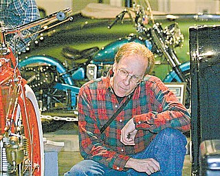 Randy Kretz of Newbury, Ohio, inspects a 1908 Crouch motorcycle at the Packard Museum on Saturday, January 8th. This is the oldest motorcycle in the museum's Motorcycles on Main Street show.