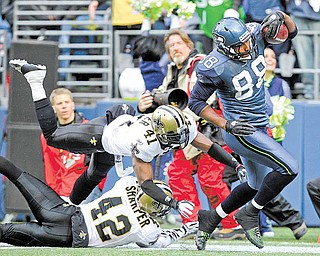 Seattle Seahawks' Cameron Morrah (88) carries the ball after a pass reception as New Orleans Saints' Roman Harper (41) and Darren Sharper (42) attempt to take him down in the first half of an NFL NFC wild card playoff football game, Saturday, Jan. 8, 2011, in Seattle. This play set the Seahawks up for a touchdown on the next play.