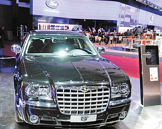 In this file photo taken Sept. 30, 2010, a model stands by the Chrysler 300 C during media day of the Paris Auto Show in Paris.