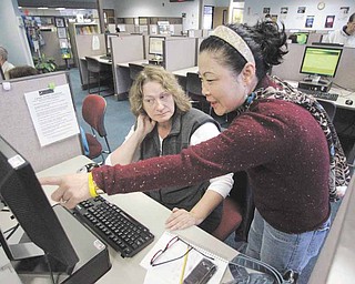 Sun Gaddis, right, a career center specialist, helps job seeker Paula Morgan, of Beaverton, who has been unemployed the last nine months Friday, Jan. 7, 2011, at WorkSource Oregon, in Tualatin, Ore. The nation's economy added 103,000 jobs in December and the unemployment rate dropped to 9.4 percent last month, its lowest level in 19 months.