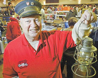 Jim Pope of Berlin Center, president of the Youngstown Model Railroad Association, holds a railroad lantern during model railroad flea market Sunday at McMenemys in Niles.