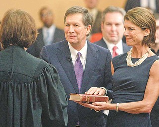 John Kasich, center, with his wife Karen, is congratulated by Justice Maureen O'Connor after bring sworn in as the new Governor of Ohio Monday, Jan. 10, 2011, in Columbus, Ohio.