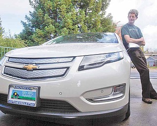 Felix Kramer, founder of CalCars, poses for a photograph next to his new Chevy Volt electric car in Redwood City, Calif., Wednesday, Dec. 29, 2010. In December, dozens of car buyers exhibited strange behaviors: They accepted the keys in front of a crowd of people, many snapping photos and taking video of the moment they picked up their new electric cars, marking the first sales of mass-produced battery-powered cars in the U.S.