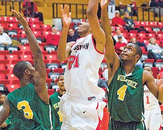 YSU Penguin Zack Rebillot drives to the basket while being defended by Christopher Olafioye (3) and Yann Sani (4) of the Wilberforce Bulldogs.