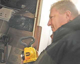 Dan Wolcott, owner of Dan's Odds & Ends in Tallmadge, surveys a storage locker that was up for auction at the U-haul storage facility on Mahoning Avenue in Youngstown. About 100 people turned out to bid on nearly 30 lockers whose renters were delinquent on their payments.
