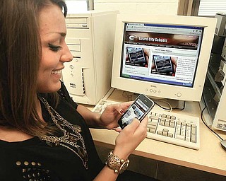 Sammy Chase, a junior at Girard Junior/Senior High School, uses her iPhone to sign up for new notification system that will alert parents, staff and students to school closings and delays. Participants have a choice of notification method — by text or e-mail.