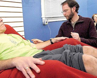 Fred Wolfson, owner of "Acupuncture For All" treats several patients at a time in a peaceful, communal room, which keeps the costs down to what a normal acupuncture procedure costs. Here, Wolfson, center, treats Ron Freeman with acupuncture needles, December 14, 2010, in Baltimore, Maryland.