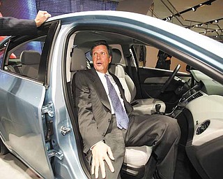 Ohio Governor John Kasich sits in a Chevy Cruze at the North American International Auto Show in Detroit.