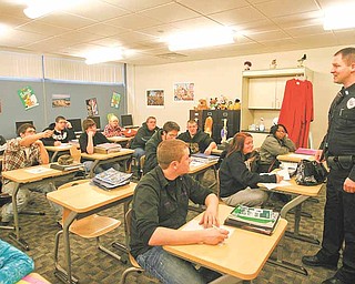 Ryan Williams, Canfield Police Department's school resource officer at the Mahoning County Career and Technical Center, talks with students in Donna Greer's English class Thursday morning. Canfield police partnered with MCCTC and Canfield High School to implement a new drug training program geared toward young adults..