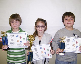 Displaying the trophies they won are, from left, Drake Beeson, second place; Skylar Sakonyi, first place; and Lukas Mosora, third place. Skylar will represent the school in Trumbull County and The Vindicator spelling bees.