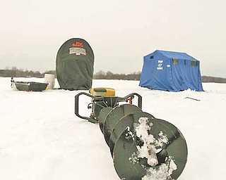 Ice Fishing is cool - A power auger for cutting through the ice sits dormant outside two ice shelters on Mosquito Lake.