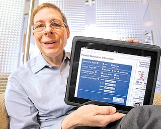 In this Friday, Jan. 14, 2011 photo, Marty Tenenbaum, a survivor of the skin cancer melanoma, shows off his free app on his iPad in his Palo Alto, Calif., office. Tenenbaum, 67, is launching a free app with Cancer Commons, a set of online tools that help professionals study the disease and help with better treatments.