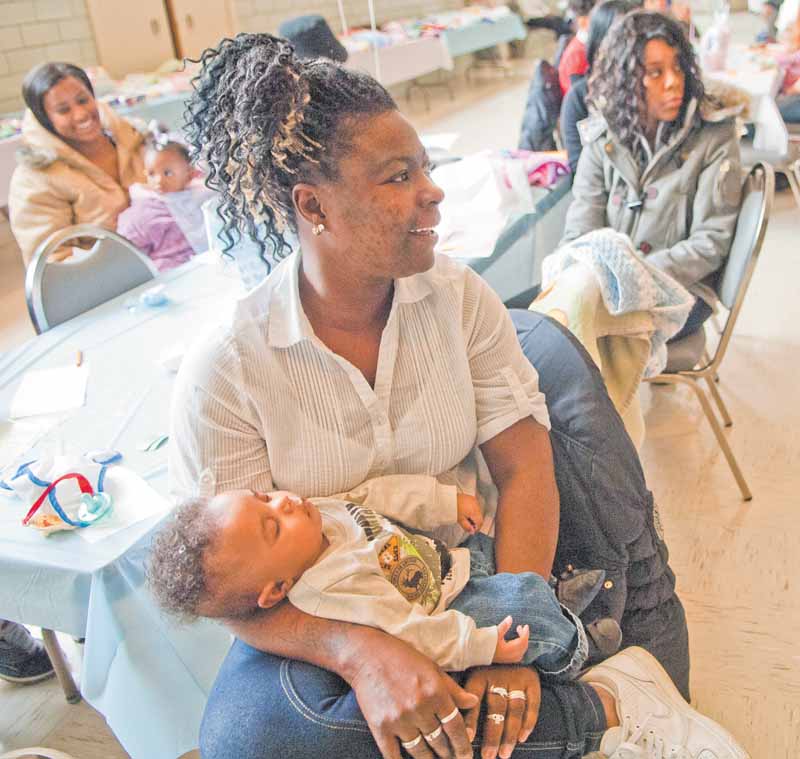 Alica Fussell of Youngstown cradles her four-month-old grandson, Xavier, at the fifth annual baby shower at the Associated Neighborhood CentersÕ McGuffey Centre in Youngstown on Monday.