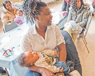 Alica Fussell of Youngstown cradles her four-month-old grandson, Xavier, at the fifth annual baby shower at the Associated Neighborhood CentersÕ McGuffey Centre in Youngstown on Monday.