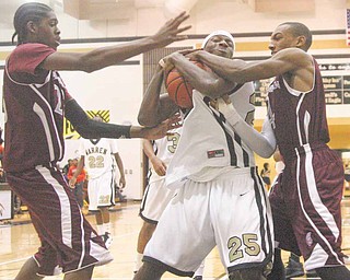 Warren Harding's Delshawn Bell (25) battles for the ball with Boardman's Leondre Jackson (23) and T.J. Irving (4) during their game Tuesday night. 