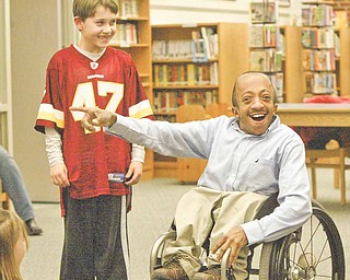 Chaz Kellem, manager of diversity initiatives for the Pittsburgh Pirates, talks about disability awareness during a parent-night program at Poland North Elementary School. Fourth-grader Kyle Koziel listens during his presentation at Wednesday’s program.