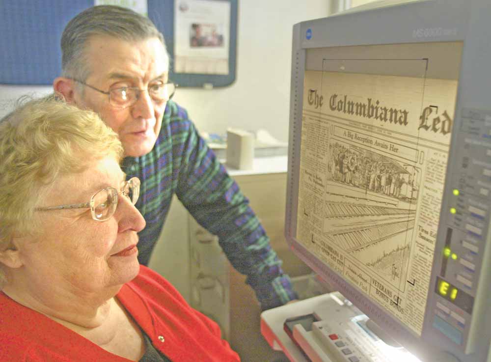 Dorothy Yakubec of Salem and DeWayne McCarty of Columbiana look at a microfilm of the Columbiana Ledger, a now defunct newspaper, at the Columbiana Public Library.