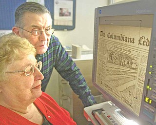 Dorothy Yakubec of Salem and DeWayne McCarty of Columbiana look at a microfilm of the Columbiana Ledger, a now defunct newspaper, at the Columbiana Public Library.