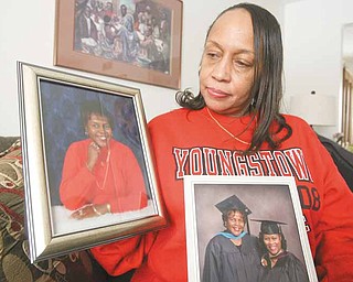 Davida Brown of Youngstown, a daughter of slain real estate broker Vivian Martin, wants the suspects charged in her mother’s death tried here. She is shown with a photo of her mother and a graduation photo of her mother and her sister, Donna James. In 2005, Martin received her master’s degree in organizational leadership from Geneva College, Geneva, Pa., and James received her master’s degree in business administration from Youngstown State University, where she is a payroll specialist.    