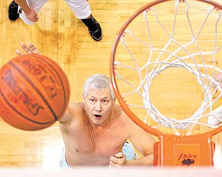 In this Jan. 7, 2011 photo, John Sugar goes up for an uncontested basket while playing a lunchtime pickup game at the Columbus Athletic Club in Columbus, Ohio. Slam-dunks are few and far between, but past-their-prime hoops players still know how to get down court, shoot - and challenge calls.