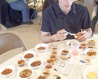 Zachariah Brewer, 18, of Boardman, tries several kinds of chili along with family members before casting his vote at the First Annual Sue Hernan Memorial Chili Cook-off.