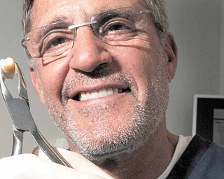 Miami Beach oral surgeon Dr. Jeffrey Blum holds a molar similar to the one that would be sent to a cryogenics lab in New York City where it would be frozen and stored. 