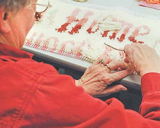 Alice Weidner of Hubbard, president of Friends of the Library in Hubbard, works on a hooked-rug project that she began a decade ago. She said the Fortnightly Craft Group has given her the motivation and inspiration to complete it..