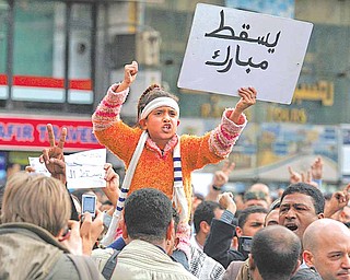 A girl holds a sign reading "Down with Mubarak" during a demonstration in Cairo, Sunday, Jan. 30, 2011. The Arab world's most populous nation appeared to be swiftly moving closer to a point at which it either dissolves into widespread chaos or the military expands its presence and control of the streets.