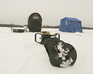 ROBERT K. YOSAY | THE VINDICATOR..Ice Fishing is cool - A power auger for cutting through the ice sits dormant outside two ice shelters on Mosquito Lake ... Ó--30-..