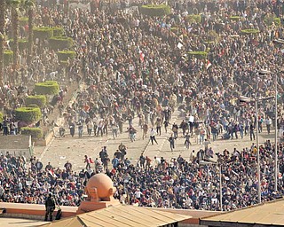Pro-government demonstrators, below, clash with anti-government demonstrators, above, as an Egyptian Army soldier on the rooftop of the Egyptian Museum observes the scene in Tahrir square, the center of anti-government demonstrations, in Cairo, Egypt Wednesday, Feb. 2, 2011. 