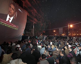 Egyptian anti-government protesters gathered in Tahrir (Liberation) square, watch a screen showing U.S. President Barack Obama live on a TV broadcast from Washington DC, speaking about the situation in Egypt, early Wednesday, Feb. 2, 2011. (AP Photo/Lefteris Pitarakis)