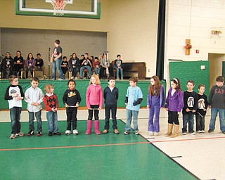 Audience is spellbound: Although they were too young to compete in the official spelling bee at St. Patrick School in Hubbard, this group of students from grades one through three lined up to demonstrate their spelling skills as older students, in the background, prepared for the local spelling bee. Family, friends and classmates were held spellbound as the youngsters competed for the first time in a classroom spelling bee. The winner of the competition was Luke Yungbluth, a student in the third grade taught by Joann Matune.