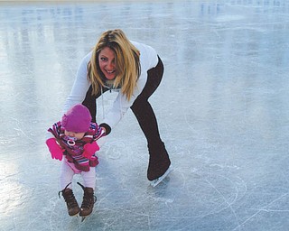 Laura Glass helps 4-month-old Alexis Spagnoletta of Girard at the ice rink Laura and her husband, Rick, built on their property in McDonald.