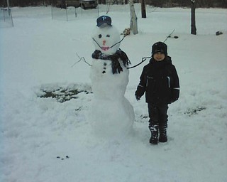 4-year-old Joshua Guy builds his first snowman at the Poland home of his grandparents, James and Sandra Guy.