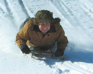 John Grantonic of Poland, who says he is still having fun at 81, sled rides with his grandkids at Mohawk Trails Golf Course in Bessemer, Pa.