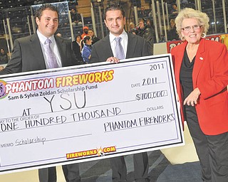 Sky’s the limit with education: Dr. Cynthia Anderson, right, president of Youngstown State University, accepts a check for $100,000 from Phantom Fireworks at a Youngstown Phantoms Hockey game. The check was presented Jan. 29 by Phantoms Hockey president and vice president, Alex Zoldan, left, and Ron Zoldan. The money is for YSU’s Sam and Sylvia Zoldan Scholarship Fund, established in memory of Alex and Ron’s grandparents, the parents of Phantom Fireworks President Bruce J. Zoldan and Vice President Alan L. Zoldan.