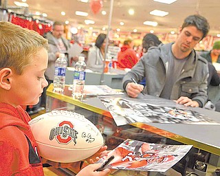Peyton Weaver of Middlefield walks away with a poster, photograph and football autographed by Ohio State University wide receiver Dane Sanzenbacher, in background. Although only 9, Peyton claims to have been fan of OSU “forever.”