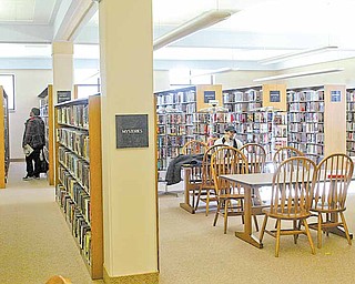 Main Library patrons look through stacks and read at a study area inside the facility. An architectural study recommends $11 million worth of improvements to the library.