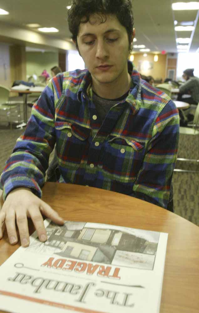YSU student Ralph Rich looks at a copy of a YSU student newspaper while talking about a shooting during an off campus party.