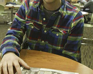 YSU student Ralph Rich looks at a copy of a YSU student newspaper while talking about a shooting during an off campus party.
