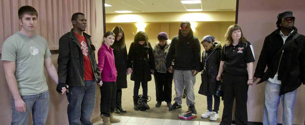 YSU students and faculty joined hands during a Monday prayer service on campus for victims of a weekend shooting.