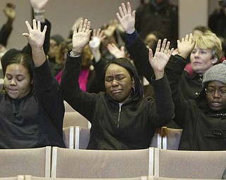 Jeanna Denson, left, Dana Thomas and Dessera McClendon participate in Monday’s prayer service at Youngstown State University, after weekend shootings left one YSU student dead.