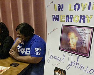 Anjalia Lyons, left, and Charesse Alexander, Youngstown State University students and members of sorority Zeta Phi Beta, collect donations before a campus prayer service for shooting victim Jamail Johnson’s family.