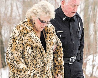 Dr. Cynthia Anderson, president of Youngstown State University, walked with a YSU police officer near the scene of a shooting at an off-campus fraternity house Sunday. Six students were hit by the gunfire, one of them fatally.